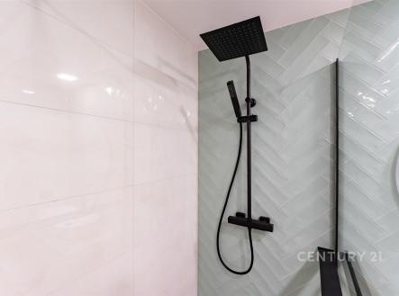 Moderní sprchový kout s matnou černou baterií, elegantní dlaždice ve světlém odstínu, luxusní design koupelny