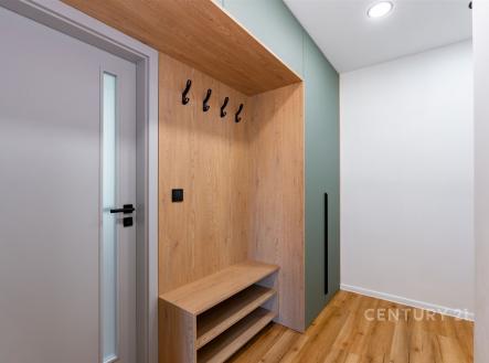 Vstupní chodba s dřevěnou vestavěnou skříní, moderní design, vinylová podlaha, praktické úložné prostory, světlé osvětlení