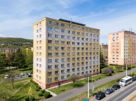 Panelový bytový dům s novými fasádními omítkami, výhled na okolní zelené plochy a klidné prostředí, dobrá dopravní dostupnost.