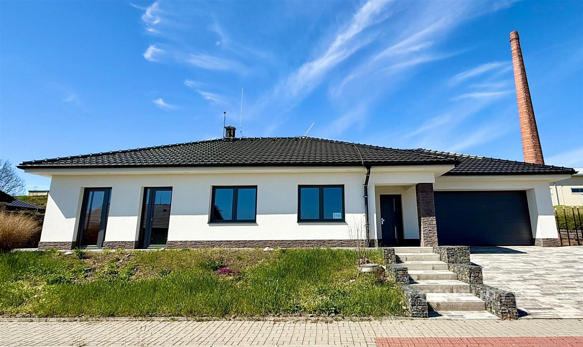 Moderní rodinný dům se zahradou, fasáda v bílé barvě, velká okna, kvalitní střešní krytina, udržovaný stav, prostorná garáž