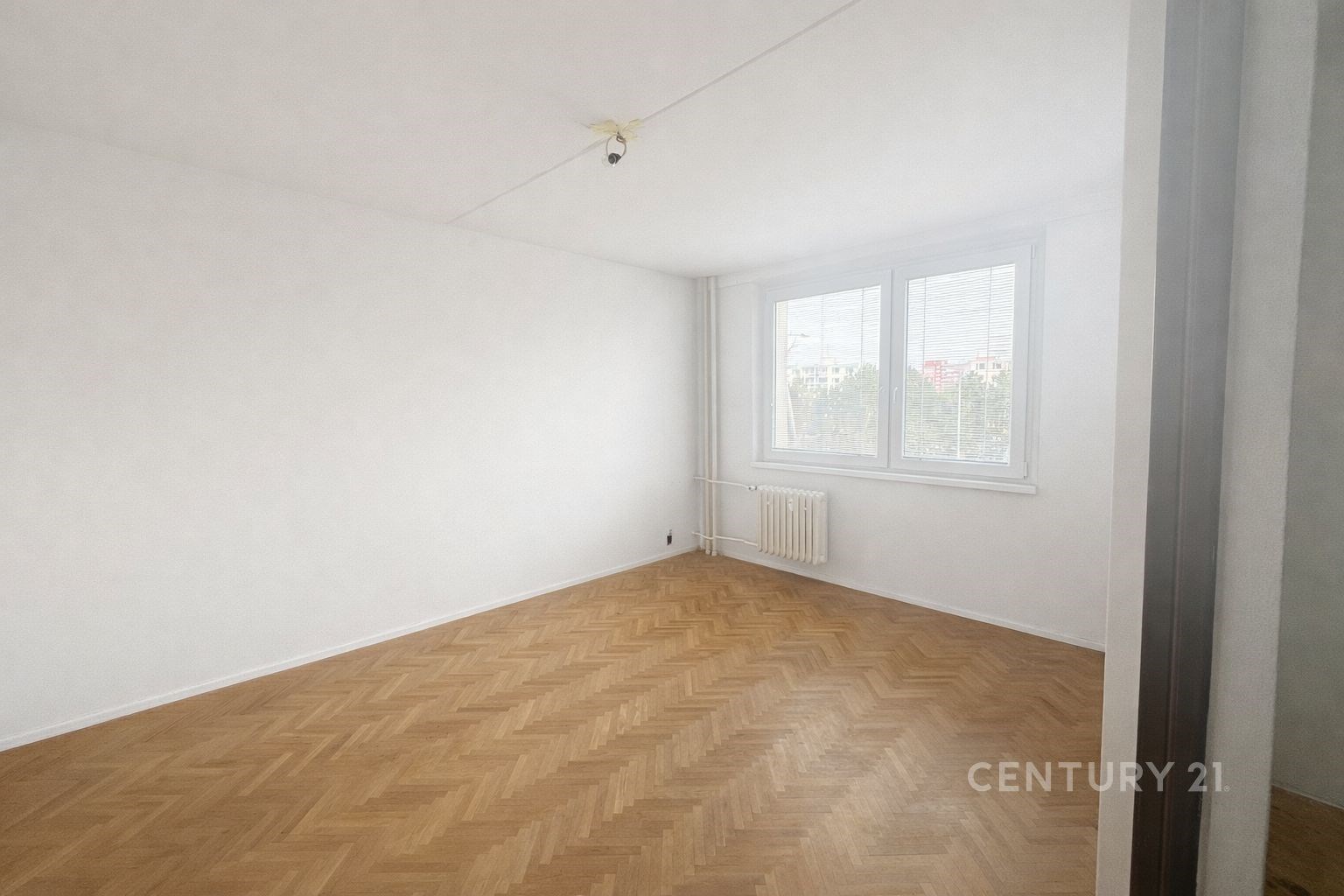 Prázdný obývací pokoj, parketová podlaha, velká okna, světlý interiér, moderní vzhled, připravený k zařízenému bydlení