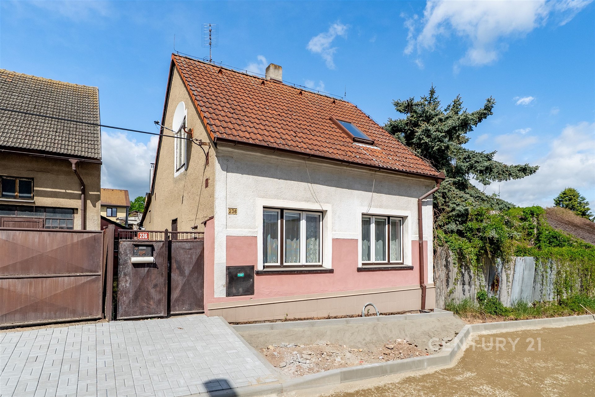 Rodinný dům s tradiční fasádou, sedlovou střechou a plastikovými okny. Klidná lokalita s částečně dokončeným chodníkem.
