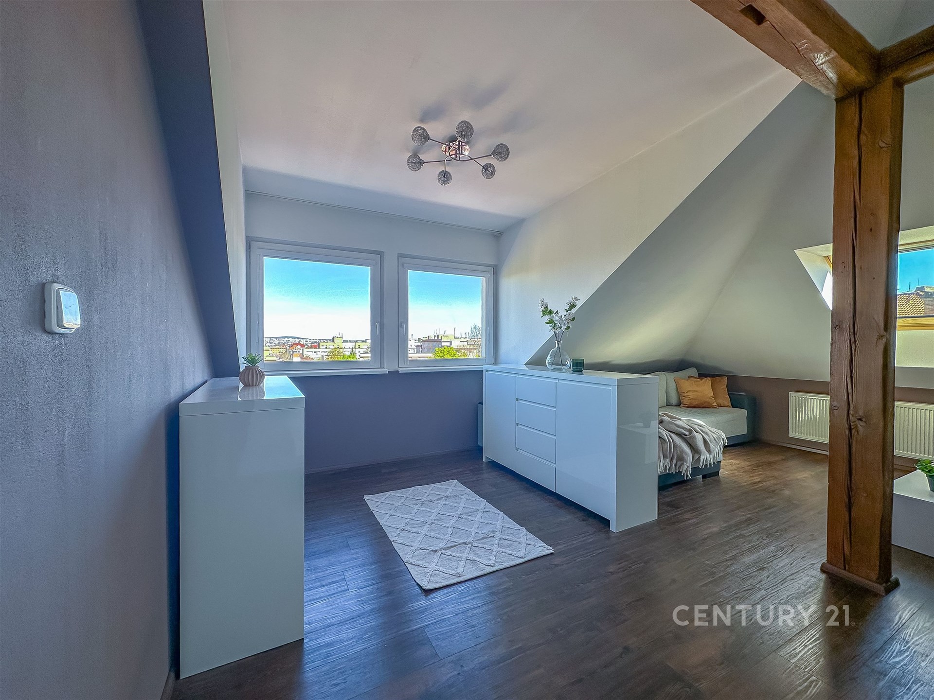 Prostorná ložnice s moderním designem, parketová podlaha, velká okna poskytující dostatek světla, elegantní bílý nábytek, útulný výklenek na spaní