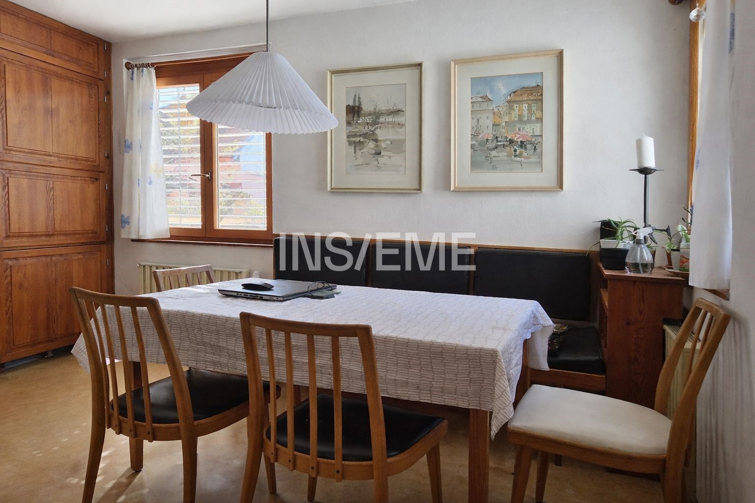 Jídelna s dřevěným nábytkem, parketovou podlahou a velkými okny, světlá a útulná atmosféra ideální pro rodinná setkání.