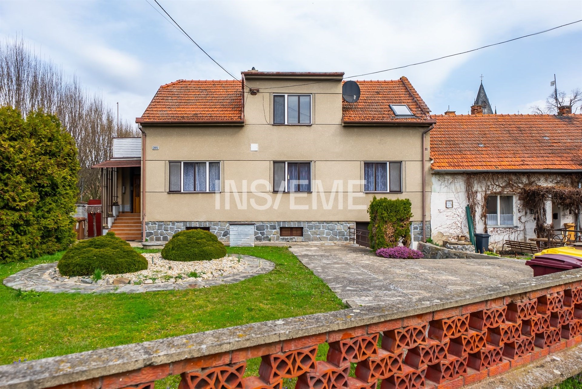 Rodinný dům s kamennými základy, cihlovou střechou a upravenou zahradou. Tiché prostředí, prostorný pozemek, vhodný pro rodiny.